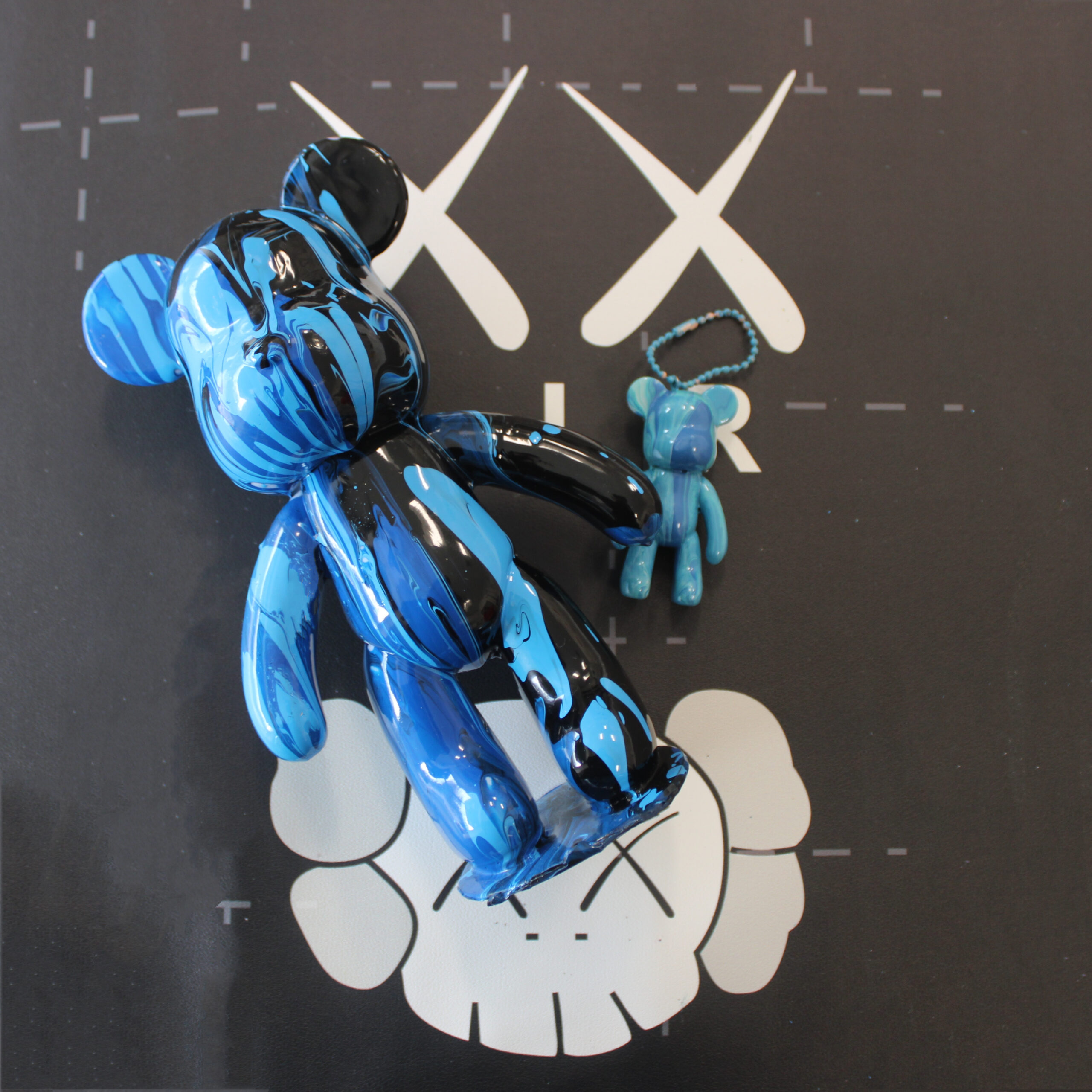 A fluid art bear sculpture featuring vibrant swirling colors and a glossy finish, blending creativity and modern art.
