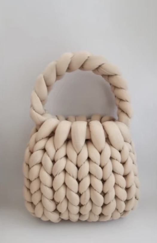 A cream-colored handwoven velvet bag featuring a chunky braided texture, displayed against a plain background.