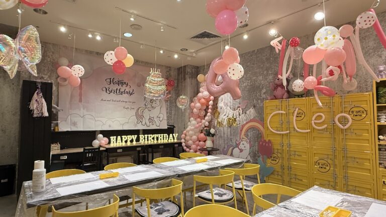 A beautifully decorated birthday party setup at Crafts Zone with pink balloons, unicorn-themed decorations, and creative craft stations.