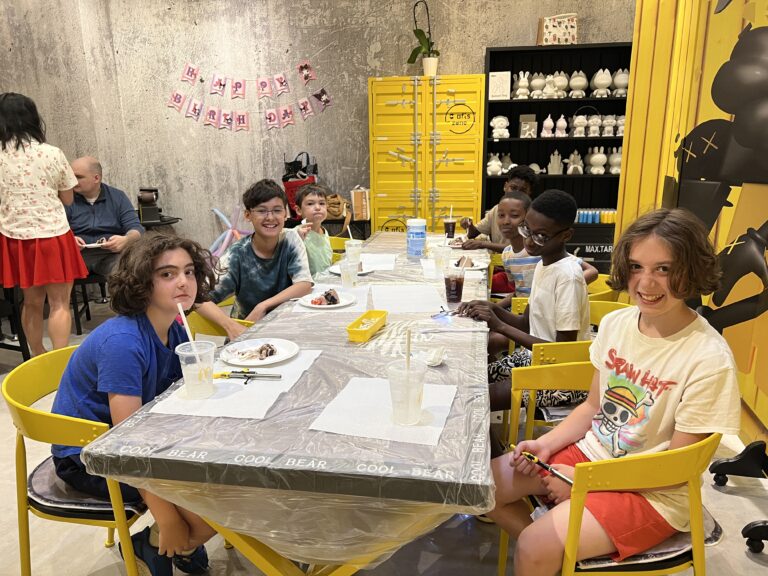 A group of happy kids enjoying a fun and creative birthday party at Crafts Zone, surrounded by vibrant decorations and craft activities.