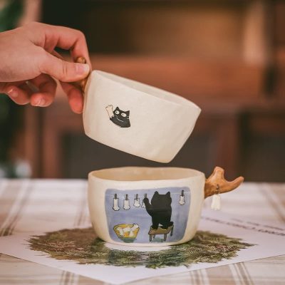 Adorable ceramic cup set with a black cat illustration and a unique deer antler handle.