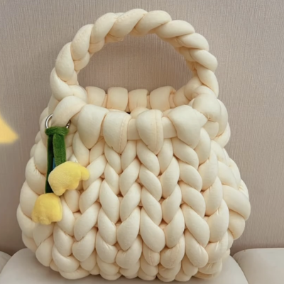 A stylish handmade plush knitted handbag with thick woven design and soft fabric, featuring a charming yellow flower accessory